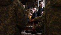 Istri tentara Tereshko Volodymyr, 44 tahun, tengah, bersedih selama upacara pemakaman suaminya, di Gereja Rasul Suci Petrus dan Paulus, di Lviv, Ukraina barat, Senin, (4/4/2022). ( AP Photo/Nariman El-Mofty)