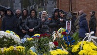 Keluarga dan teman menghadiri pemakaman sersan Kostiv Andrew berusia 37 tahun, yang tewas dalam aksi, di pemakaman Lychakiv, di Lviv, Ukraina barat, Selasa, (5/4/2022). (AP Photo/Nariman El-Mofty)