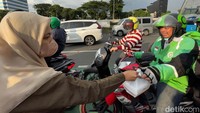 Seorang mahasiswi membagikan takjil kepada driver Ojol.