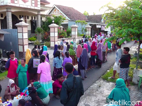Antrean panjang ratusan warga untuk mendapatkan minyak goreng curah harga HET di Lumajang sampai menutup jalan desa.