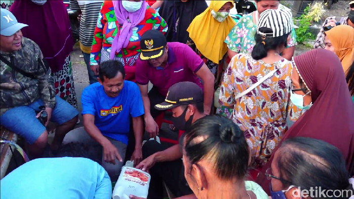 Antrean panjang ratusan warga untuk mendapatkan minyak goreng curah harga HET di Lumajang sampai menutup jalan desa.