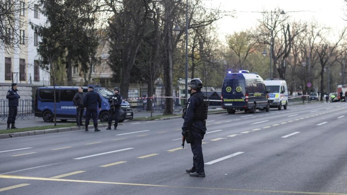 Police officers stand guard as crime scene investigators check the area where a car crashed into the gate of the Russian Embassy in Bucharest, Romania, April 6 2022. Inquam Photos/Octav Ganea via REUTERS ATTENTION EDITORS - THIS IMAGE WAS PROVIDED BY A THIRD PARTY. ROMANIA OUT. NO COMMERCIAL OR EDITORIAL SALES IN ROMANIA