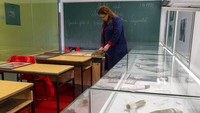 Arijana Djidelija, guru sekolah dasar berusia 52 tahun memeriksa buku catatan di ruang kelas peringatan di sebuah sekolah tempat tiga siswa dan seorang guru tewas selama perang 1992-1995, di Sarajevo, Bosnia.