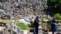Sepasang suami istri membakar uang kertas di makam kerabat di pemakaman selama Chinese Ching Ming, atau Hari Pembersihan Makam.