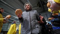 Warga mengambil roti yang disediakan saat pendistribusian bantuan kemanusiaan digelar di sebuah toko yang rusak di kawasan Mariupol, Ukraina. REUTERS/Alexander Ermochenko.