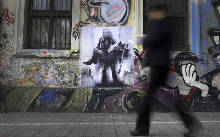 Seniman Bikin Mural Presiden Putin Bopong Mayatnya Sendiri Seorang seniman Bulgaria, Stanislav Beloski mengungkapkan protes terhadap invasi Rusia ke Ukraina. Ia membuat mural di dinding Ibu Kota Sofia dengan menyudutkan Presiden Putin. Seperti apa gambarnya?
