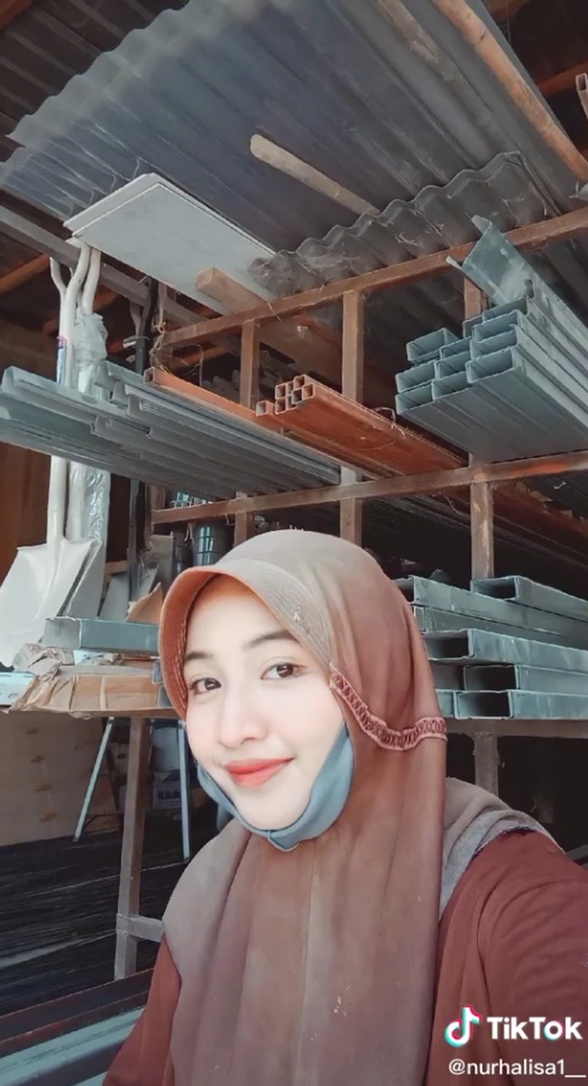 Ialah Nur Aini atau Nur Halisa tak hanya fokus belajar di sekolah tapi membantu kedua orangtuanya untuk menjadi kuli angkat semen. Remaja tersebut viral, usai mengunggah video saat berada di sebuah toko bangunan dan ada satu truk tronton yang parkir di depan toko bangunan. Tronton tersebut mengangkut semen yang akan dibongkar muat ke toko bangunan. Foto: Dok. TikTok @nurhalisa1__.
