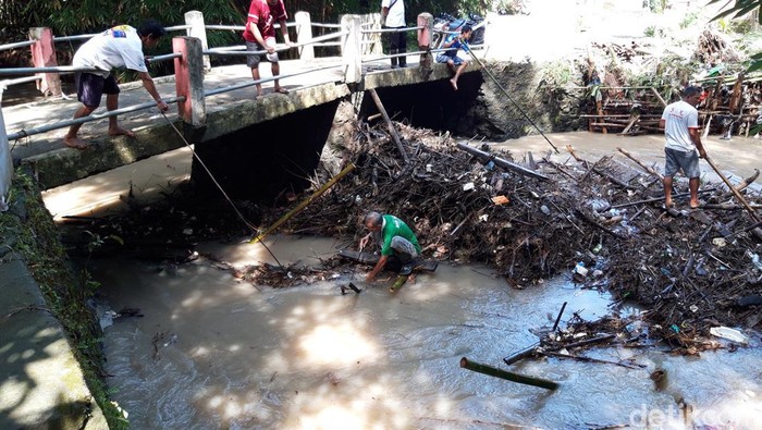 Warga Boyolali membersihkan sampah yang tersangkut jembatan usai banjir, Rabu (6/4/2022).