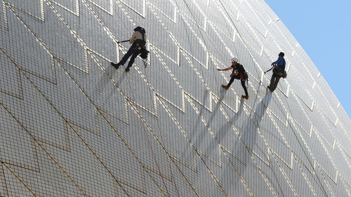 SYDNEY, AUSTRALIA - APRIL 05: Building Operations staff inspect tiles on the Sydney Opera House sails on April 05, 2022 in Sydney, Australia. The 'tile tapping' test is conducted every five years to inspect the health of the tiles that cover the Sydney Opera Houses' iconic sails and takes six weeks to complete. A specific type of hammer is used to lightly tap the tiles with each tile emitting a particular type of sound which indicates whether it is due for repair or still in good condition. There is a limited supply of backup tiles in stock for replacement, so the tile tapping check is an essential maintenance activity for the building. (Photo by Mark Metcalfe/Getty Images)