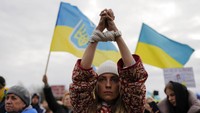 Seorang wanita mengikat tangannya selama demonstrasi untuk menggambarkan penderitaan warga Ukraina.
