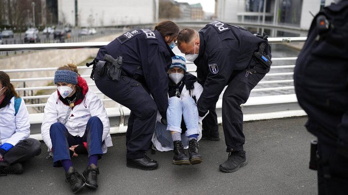 Demi Iklim Lebih Baik, Aktivis Mengelem dan Merantai Diri Sejumlah aktivis lingkungan berdemo menuntut upaya perbaikan iklim di Berlin, Jerman, Rabu (6/4). Mereka bahkan merantai diri dan mengelem tangannya ke jalan.