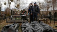 Seorang petugas mencatat identitas jenazah yang akan dikubur. Militer Ukraina merebut kembali kendali atas kota Bucha di pinggiran Kiev hanya beberapa hari lalu dan menyatakan pihaknya menemukan puluhan mayat, tak lama setelah Rusia menarik pasukannya dari area tersebut.