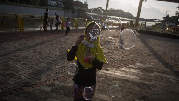 Seorang anak bermain gelembung sabun di Taman Bendung Tirtonadi, Solo, Jawa Tengah.