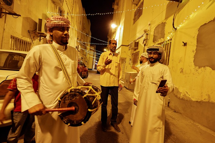 Ali Sammak plays a drum while Yasser Sammak sings religious songs, keeping the tradition of Mesaharati, to wake up Muslims to have the pre-dawn meal before they start their fast, during the holy month of Ramadan, in Jidhafs, Manama, Bahrain, April 6, 2022. REUTERS/Hamad I Mohammed