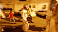 Warga berkeliling membangunkan sahur puasa Ramadan di Manama, Ibu Kota Bahrain, Rabu (6/4/2022) waktu setempat. Tradisi ini dinamakan Mesaharati.   