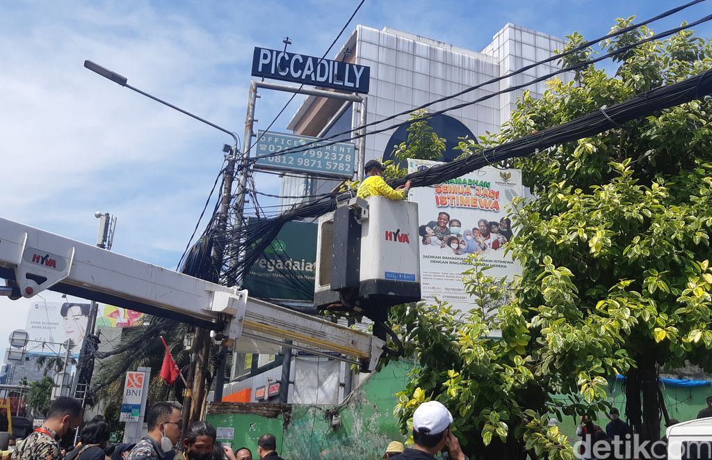 Pasukan kuning dari Dinas Bina Marga DKI Jakarta memotong kabel semrawut di Jl Mampang Prapatan Raya, Jakarta Selatan, 7 April 2022. (Danu Damarjati/detikcom)