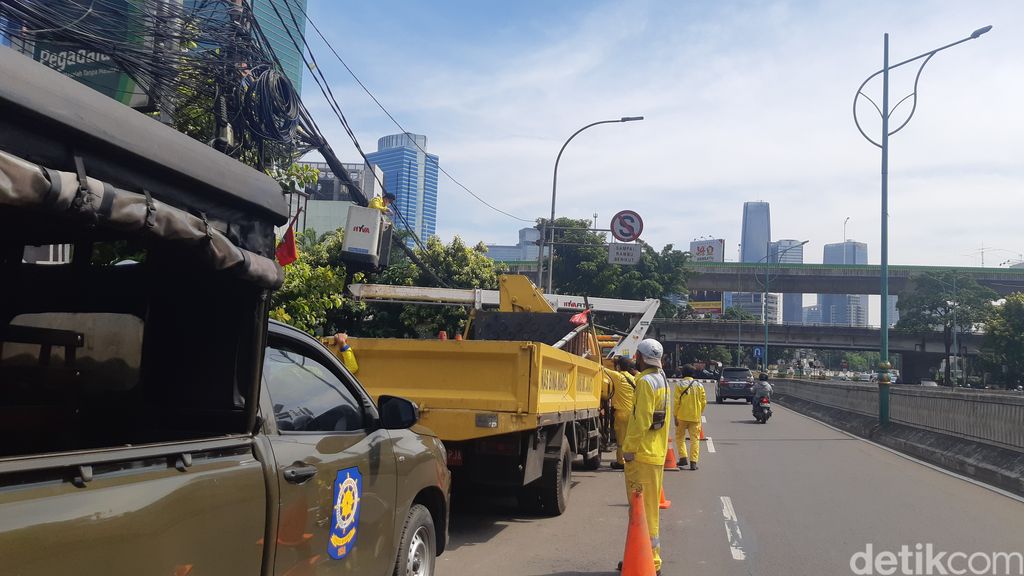 Pasukan kuning dari Dinas Bina Marga DKI Jakarta memotong kabel semrawut di Jl Mampang Prapatan Raya, Jakarta Selatan, 7 April 2022. (Danu Damarjati/detikcom)