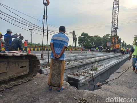 Pemasangan girder Jembatan Balun di Jalan Nasional Lamongan. Setelah tuntas, akses melewati jalan yang tersisa di jembatan yang ambles itu dibuka lagi.
