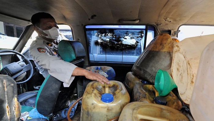 Polisi menunjukkan beberapa jeriken berisi solar subsidi yang ditumpuk di dalam mobil yang sudah dimodifikasi saat ungkap kasus penyalahgunaan BBM solar bersubsidi di Mapolres Muarojambi, Jambi, Rabu (6/4/2022). Dalam empat bulan terakhir, Kepolisian Daerah setempat berhasil mengungkap 13 kasus penyalahgunaan solar bersubsidi dan mengamankan 14 ribu liter lebih solar, 3 ribu liter minyak oplosan, 12 ribu liter minyak tanah dan 10 unit mobil/mini bus di 8 kabupaten povinsi itu dengan beberapa modus di antaranya modifikasi mobil. ANTARA FOTO/Wahdi Septiawan/rwa.