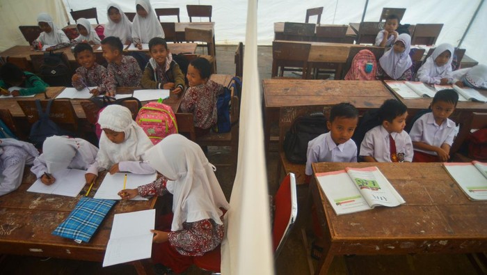 Siswa Terdampak Gempa Pasaman Barat Belajar di Sekolah Darurat Sejumlah siswa mengikuti kegiatan belajar mengajar tatap muka di dalam tenda darurat di SDN 21 Kecamatan Pasaman, Nagari Aua Kuniang, Kabupaten Pasaman Barat, Sumatera Barat, Kamis (7/4/2022). Proses belajar mengajar (PBM) tingkat SD dan SMP di kabupaten yang terdampak gempa magnitudo 6,1 pada Februari lalu itu kini kembali dibuka selama Ramadhan, namun sebagian siswa terpaksa belajar di bawah tenda darurat karena bangunan sekolah mereka rusak. ANTARA FOTO/Iggoy el Fitra/wsj.