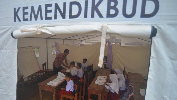 Siswa Terdampak Gempa Pasaman Barat Belajar di Sekolah Darurat Sejumlah siswa mengikuti kegiatan belajar mengajar tatap muka di dalam tenda darurat di SDN 21 Kecamatan Pasaman, Nagari Aua Kuniang, Kabupaten Pasaman Barat, Sumatera Barat, Kamis (7/4/2022). Proses belajar mengajar (PBM) tingkat SD dan SMP di kabupaten yang terdampak gempa magnitudo 6,1 pada Februari lalu itu kini kembali dibuka selama Ramadhan, namun sebagian siswa terpaksa belajar di bawah tenda darurat karena bangunan sekolah mereka rusak. ANTARA FOTO/Iggoy el Fitra/wsj.
