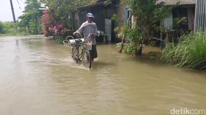 Tanggul Waduk Rancang yang jebol merendam jalan desa, permukiman, dan persawahan warga di empat dusun Desa Rancangkenongo.