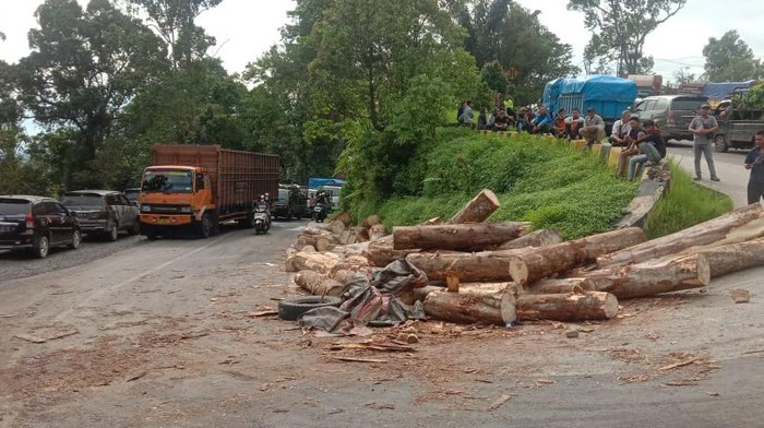 Truk pengangkut kayu gelondongan terbalik di jalur Medan-Berastagi.