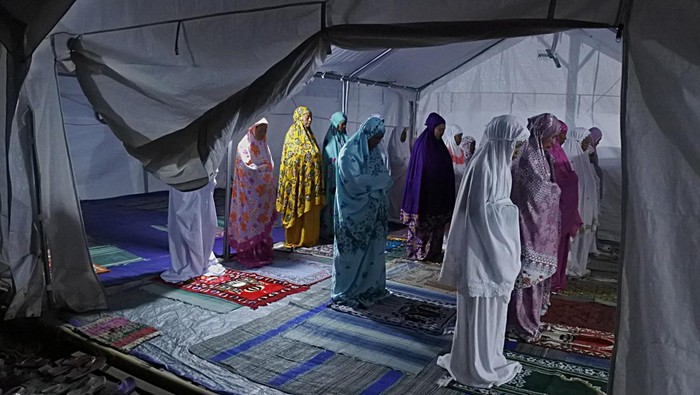 Sejumlah relawan memasak sajian berbuka puasa untuk pengungsi awan panas guguran (APG) Gunung Semeru di posko pengungsian Lapangan Desa Penanggal, Candipuro, Lumajang, Jawa Timur, Rabu (6/4/2022). Posko dapur umum Tagana Provinsi Jawa Timur menyiapkan 450 bungkus sajian berbuka puasa dan sahur bagi pengungsi APG Gunung Semeru. ANTARA FOTO/Seno/rwa.