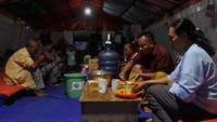 Pengungsi awan panas guguran (APG) Gunung Semeru menyantap sajian berbuka puasa di posko pengungsian Lapangan Desa Penanggal, Candipuro, Lumajang, Jawa Timur.