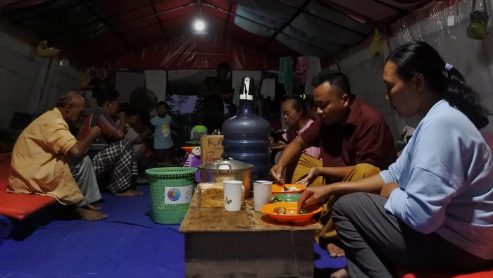 Sejumlah relawan memasak sajian berbuka puasa untuk pengungsi awan panas guguran (APG) Gunung Semeru di posko pengungsian Lapangan Desa Penanggal, Candipuro, Lumajang, Jawa Timur, Rabu (6/4/2022). Posko dapur umum Tagana Provinsi Jawa Timur menyiapkan 450 bungkus sajian berbuka puasa dan sahur bagi pengungsi APG Gunung Semeru. ANTARA FOTO/Seno/rwa.