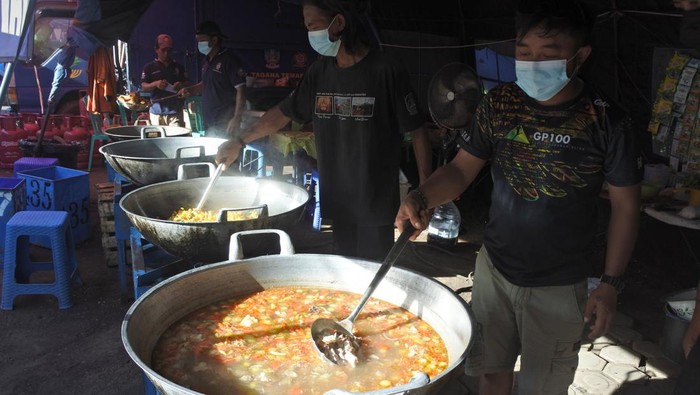 Warga Terdampak Erupsi Semeru Menjalani Ramadan di Pengungsian Sejumlah relawan memasak sajian berbuka puasa untuk pengungsi awan panas guguran (APG) Gunung Semeru di posko pengungsian Lapangan Desa Penanggal, Candipuro, Lumajang, Jawa Timur, Rabu (6/4/2022). Posko dapur umum Tagana Provinsi Jawa Timur menyiapkan 450 bungkus sajian berbuka puasa dan sahur bagi pengungsi APG Gunung Semeru. ANTARA FOTO/Seno/rwa.