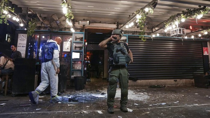 Israeli security forces search for assailants near the scene of a shooting attack in Tel Aviv, Israel, Thursday, April 7, 2022. Israeli health officials say two people were killed and at least eight others wounded in a shooting in central Tel Aviv. The shooting on Thursday evening, the fourth attack in recent weeks, occurred in a crowded area with several bars and restaurants. (AP Photo/Ariel Schalit)