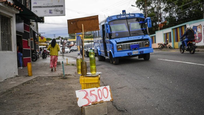 BBM Langka di Venezuela, Harga Eceran Melambung Tinggi Plastic bottles with gasoline are displayed for sale with a price in Colombian currency, in San Cristobal, Venezuela, Thursday, April 7, 2022. Amid the fuel shortage outside of Venezuela's capital, drivers are only allowed to buy 40 liters of gasoline a week, and black marketeers along the Venezuelan-Colombian border sell it only in Colombian currency or US Dollars, for twice its original price. (AP Photo/Matias Delacroix)