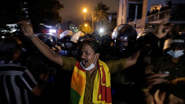 Dilanda Krisis, Bentrokan Terjadi di Dekat Rumah PM Sri Lanka Police officers try to hold the metal barrier gates as demonstrators pull it off during a protest near Temple Trees Prime Minister Mahinda Rajapaksa's official residence, amid the country's economic crisis in Colombo, Sri Lanka, April 7, 2022. REUTERS/Dinuka Liyanawatte
