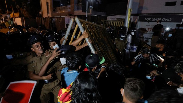 Police officers try to hold the metal barrier gates as demonstrators pull it off during a protest near Temple Trees Prime Minister Mahinda Rajapaksa's official residence, amid the country's economic crisis in Colombo, Sri Lanka, April 7, 2022. REUTERS/Dinuka Liyanawatte