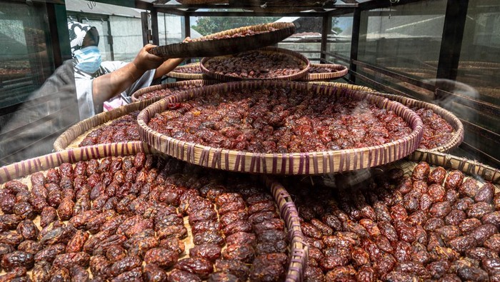 Pekerja menjemur makanan olahan tomat rasa kurma atau Torakur di sebuah industri rumahan Torakur Ngesti di Ampelgading, Bandungan, Kabupaten Semarang, Jawa Tengah, Kamis (7/4/2022). Produksi makanan alternatif sajian saat berbuka puasa maupun oleh-oleh khas Bandungan, Kabupaten Semarang seharga Rp20 ribu hingga Rp40 ribu per bungkus tersebut sempat berhenti akibat pandemi COVID-19, dan mulai produksi kembali dengan adanya pesanan dari Pemprov Jawa Tengah dan Pemkab Semarang sebagai upaya membangkitkan UMKM lokal yang terdampak pandemi. ANTARA FOTO/Aji Styawan/wsj.