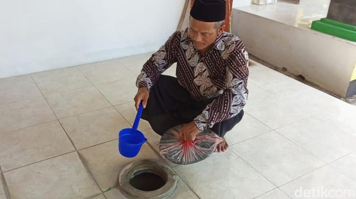 Juru Kunci Makam Nyai Ageng Maloka, Mukharom saat mengambil air gentong, Rabu (6/4/2022).