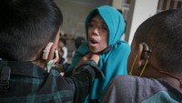Para guru akan mengajari muridnya dengan metode gerak bibir dan merasakan getaran pita suara.   