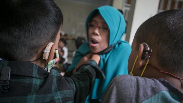 Guru mengajari siswa penyandang tuna rungu membaca Iqra dengan metode membaca gerak bibir saat mengikuti kegiatan Pesantren Kilat Ramadhan Tuna Rungu di SLB B Prawestri, Karanganyar, Jawa Tengah, Kamis (7/4/2022). Kegiatan yang dilaksanakan setiap bulan Ramadhan tersebut untuk mengajari siswa penyandang tuna rungu pengetahuan agama, tata cara shalat, membaca Iqra hingga Al Quran dengan metode gerak bibir dan merasakan getaran pita suara. ANTARA FOTO/Mohammad Ayudha/wsj.