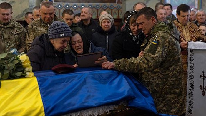 Momen Penuh Haru Pemakaman Prajurit Ukraina yang Gugur dalam Perang RUSYN, UKRAINE - APRIL 03: Family and friends mourn as Ukrainian soldier Dmitry Zhelisko is buried on April 03, 2022 in Rusyn, Ukraine. Zhelisko died fighting the Russian army near the town of Kharkiv. More than five weeks since the Russian invasion began, Ukraine's military losses are still unclear, with the last official account coming on March 12, when the government acknowledged that 1,300 Ukrainian soldiers had been killed. (Photo by Joe Raedle/Getty Images)