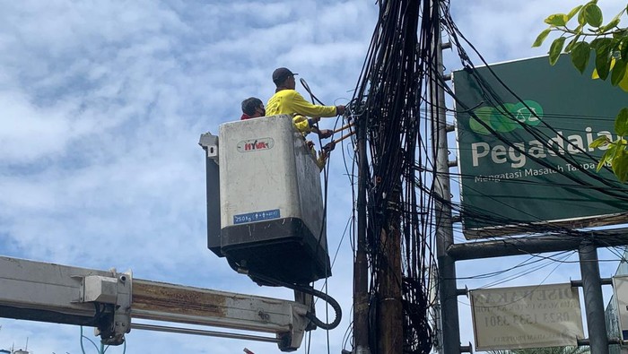 Pemotongan kabel oleh petugas Bina Marga DKI Jakarta di Jl Mampang Prapatan, Jumat (8/4/2022).