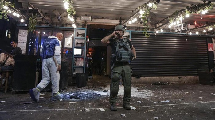 Israeli police inspect the scene of a shooting attack In Tel Aviv, Israel, Thursday, April 7, 2022. Israeli police say several people were wounded in a shooting in central Tel Aviv. The shooting on Thursday evening occurred in a crowded area with several bars and restaurants. (AP Photo/Ariel Schalit)