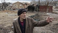 Petro Hlystun (71) berdiri di depan rumah-rumah yang hancur, saat invasi Rusia ke Ukraina berlanjut, di desa Yahidne, dekat Chernihiv, Ukraina, 6 April 2022.