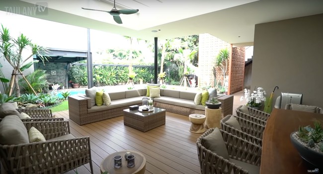 Di bagian luar rumahnya juga terdapat ruangan semi outdoor yang bisa digunakan untuk bersantai. Ruangan tersebut terletak di samping kolam renang. Bikin serasa seperti berada di villa di Bali bukan? Foto: YouTube/Taulany TV