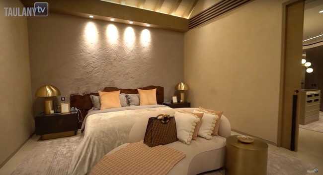 Inilah ruangan kamar milik Maia Estianty. Terlihat salah satu temboknya dicat dengan hasil yang dibuat bertekstur. Hal itu menambah estetika di kamar Maia. Di depan kasurnya juga terdapat sebuah sofa untuk bersantai. Foto: YouTube/Taulany TV