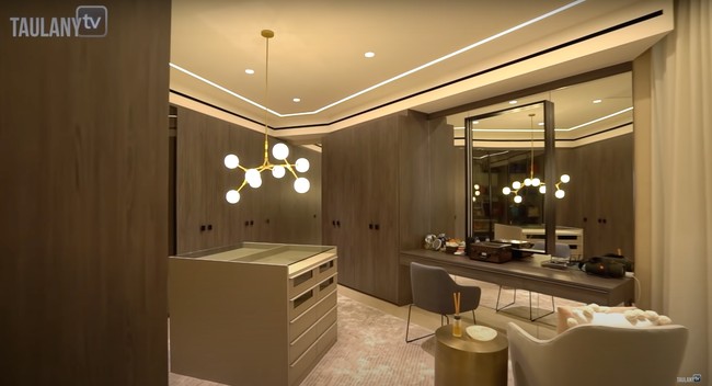 Kamar Maia Estianty juga dilengkapi dengan walk in closet yang luas. Dalam ruangan tersebut terpasang meja rias dengan kaca yang cukup besar. Di bagian tengah ruangan terdapat lampu gantung yang diletakkan di atas lemari untuk menyimpan aksesori milik Maia. Foto: YouTube/Taulany TV