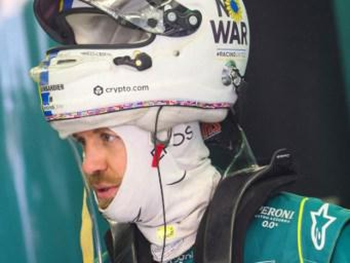 A No War message is seen on the helmet of Aston Martins German driver Sebastian Vettel during the second day of Formula One (F1) pre-season testing at the Bahrain International Circuit in the city of Sakhir on March 11, 2022. (Photo by Giuseppe CACACE / AFP)