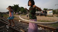 Dua anak bermain hula hoop saat ngabuburit dolanan di Kampung Dolanan, Surabaya, Jawa Timur, Jumat (8/4/2022).   