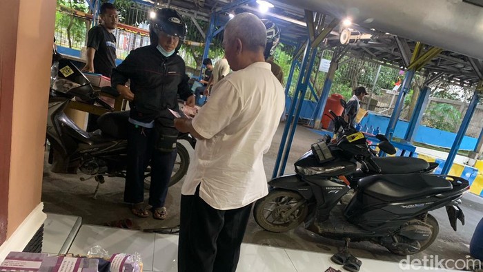 Haji Endang sedang mempersiapkan uang untuk penukaran.