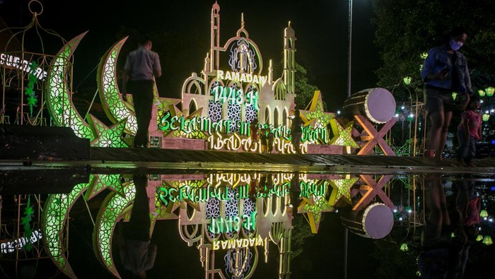 Warga berfoto dengan latar belakang instalasi lampion bertema Ramadan di Balai Kota, Solo, Jawa Tengah, Selasa (5/4/2022). Hiasan instalasi lampu lampion tersebut untuk menyemarakan bulan Ramadhan sekaligus upaya menarik kunjungan wisata religi Kota Solo. ANTARA FOTO/Mohammad Ayudha/hp.